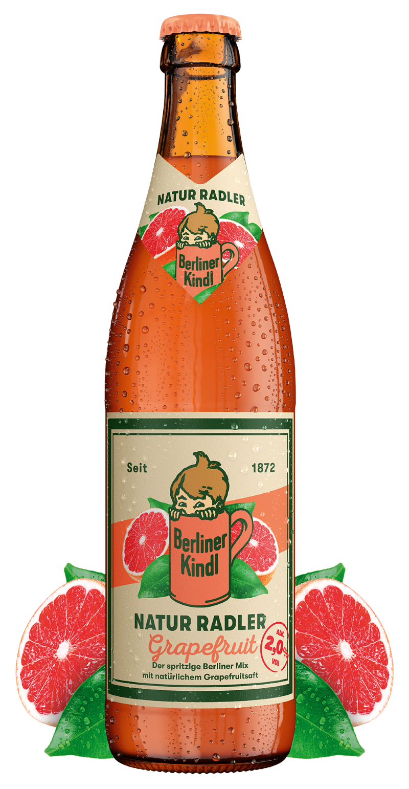 Eine Flasche Berliner Kindl Natur Radler Grapefruit neben einer aufgeschnittenen Grapefruit